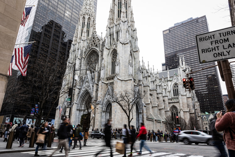 St. Patrick's Cathedral exterior view, people walk outside on the street