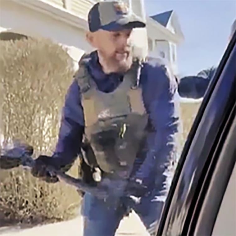 An ICE agent smashes the Marilu Mendez's car window in New Bedford, Mass.
