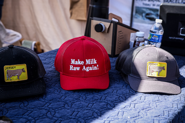 A vendor sells "Make Milk Raw Again" hats