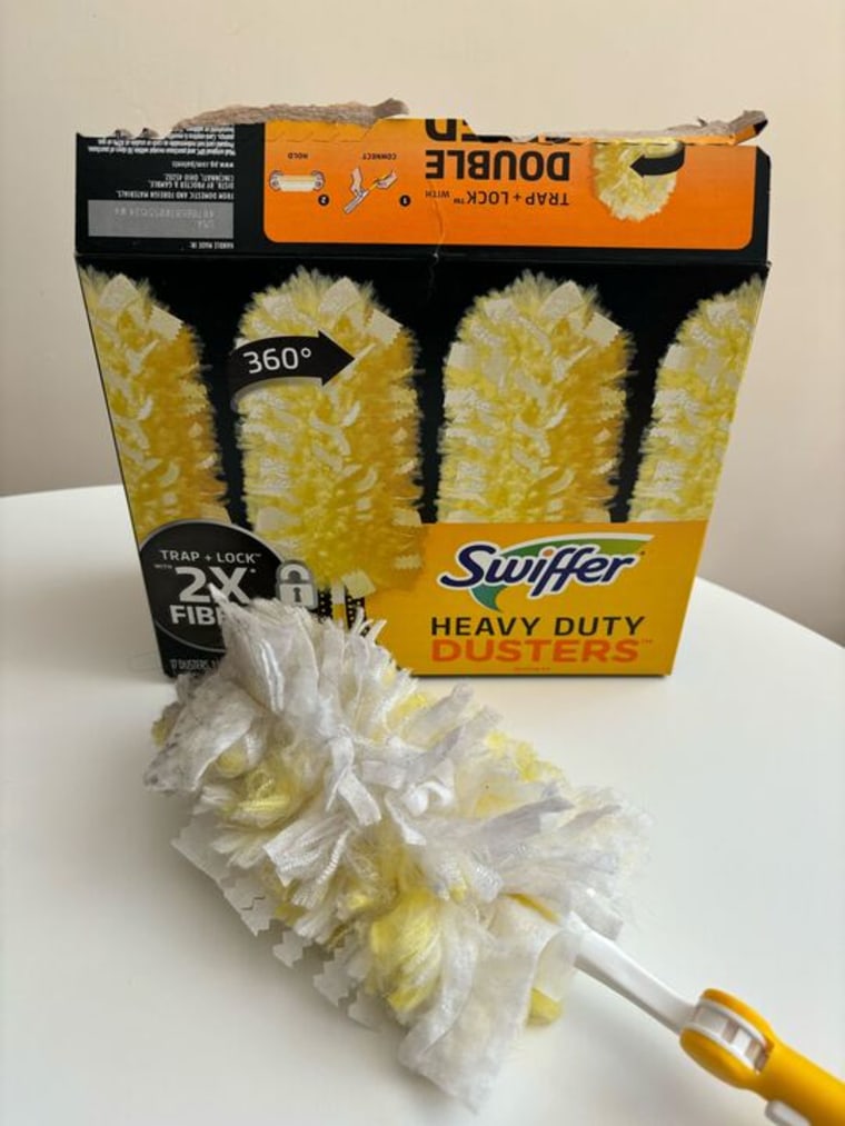 A box of Swiffer Duster refills and a Swiffer Duster sitting on a white table.