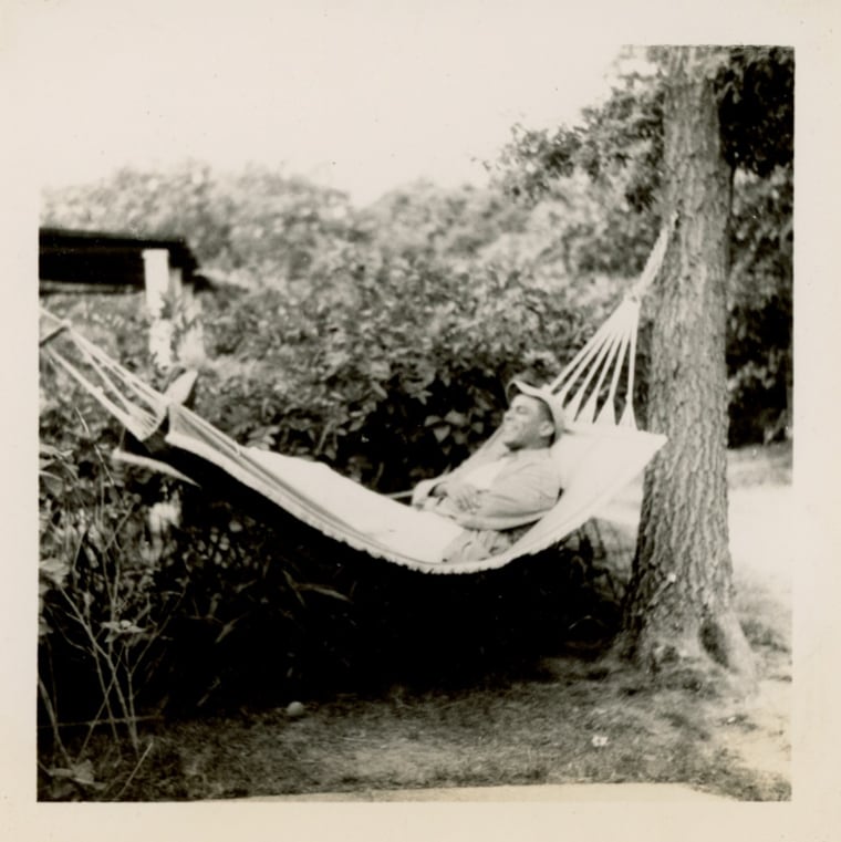 Man in casual clothes and baseball cap relaxing in a hammock
