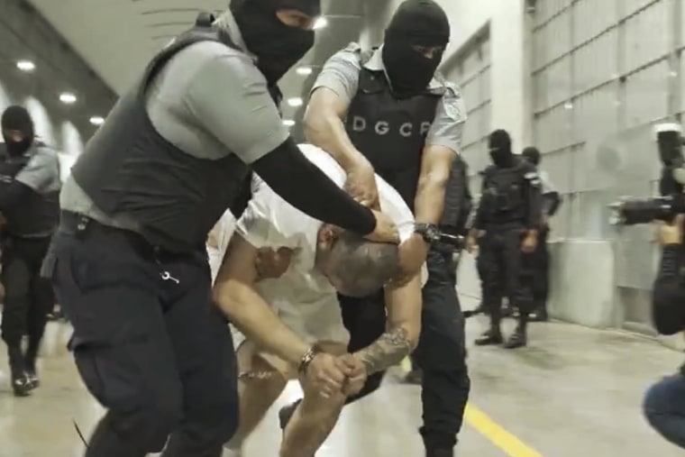 A man identified by Jennifer Vasquez Sura as her husband, Kilmar Abrego Garcia, is led by guards through the Terrorism Confinement Center in Tecoluca, El Salvador.